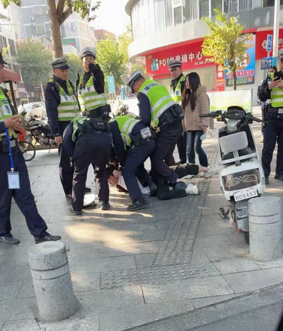 网友投稿：广州番禺，一名男子为了保护自己的电动车，被数名交警制服在地查看原文