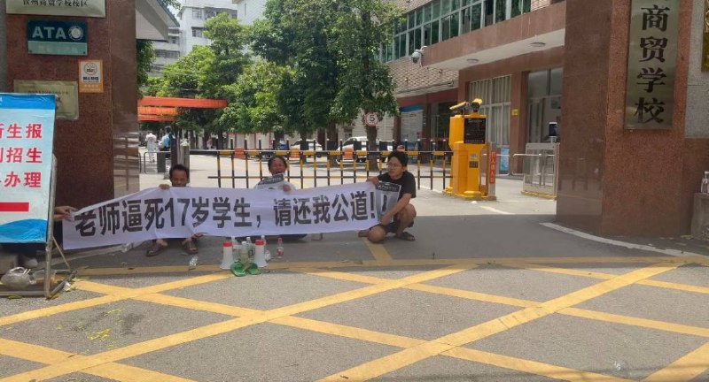 6月21日，广西，钦州商贸学校门口有家属拉起横幅维权