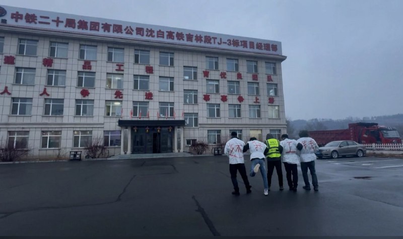 11月13日，吉林省通化市通化县，中铁二十局集团有限公司沈白高铁吉林段TJ-3标项目经理部大门前，几名工人穿“还我工钱”标语的衣服来讨要自己的工资