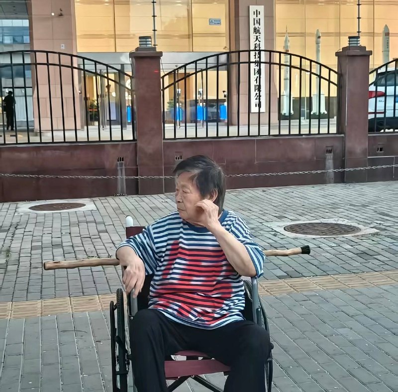 近日，陕西中国航天科技集团有限公司门前，一名坐在轮椅上的阿姨身穿印有“冤”字的T恤，在现场维权