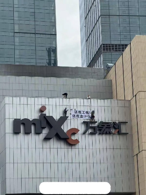 高空讨薪9月9日，央企华润集团旗下南京城北万象汇，几名讨薪工人通过绳索在万象汇外墙巨型logo上展示讨薪标语：还我工钱，还我血汗钱