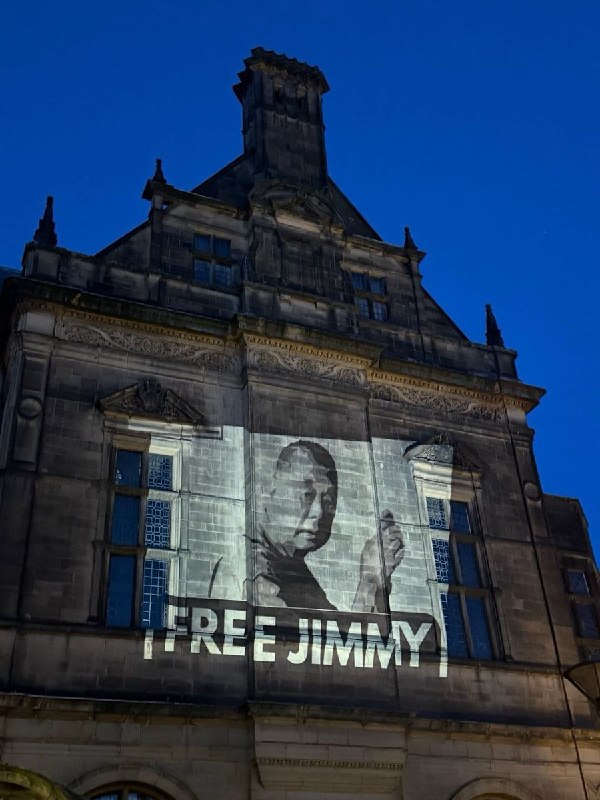 1月11日，英国谢菲尔德市政厅外，市政厅墙面被民众投影出“释放黎智英”的标语和海报