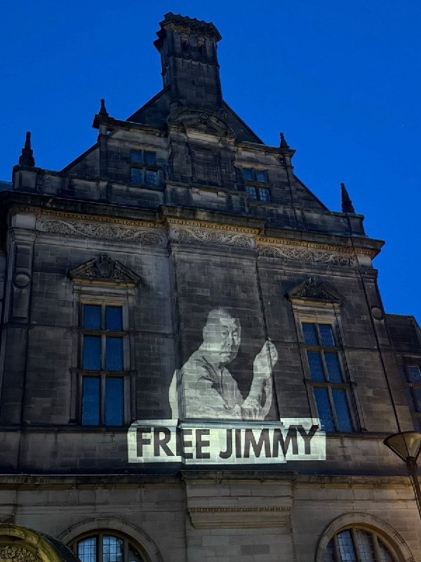 1月11日，英国谢菲尔德市政厅外，市政厅墙面被民众投影出“释放黎智英”的标语和海报