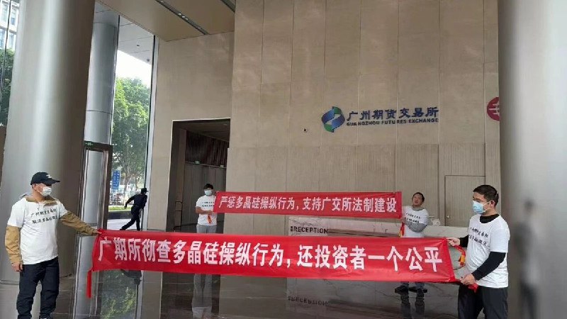 12月19日，多名投资者在广州期货交易所大厅内拉起“彻查多晶硅操纵行为，还投资者公平交易环境”“严厉打击多晶硅操纵，维护期货市场法治秩序”的横幅进行直播维权