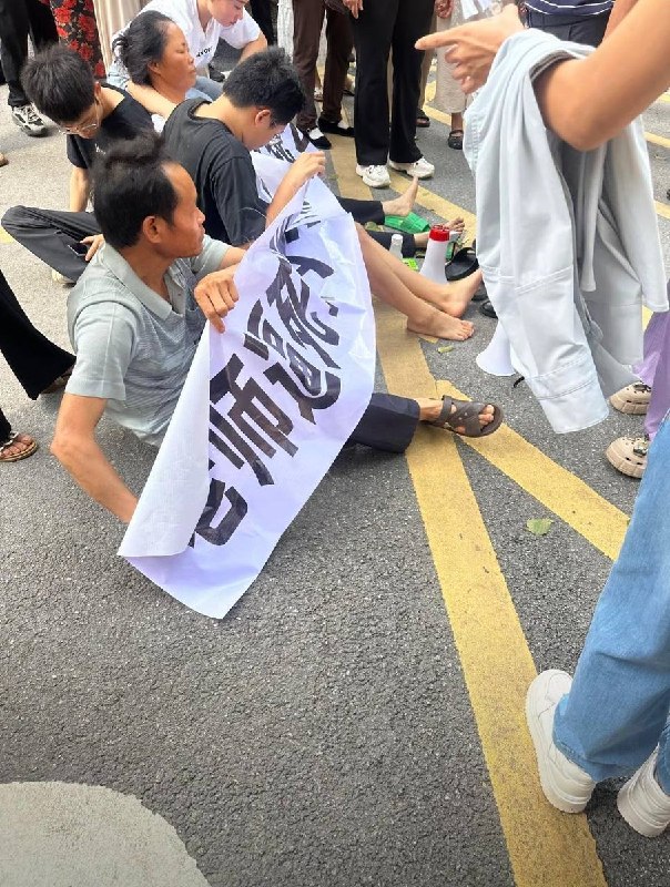 6月21日，广西，钦州商贸学校门口有家属拉起横幅维权