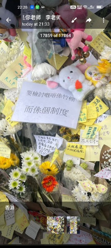 11月30日，市民在悼念死者的鲜花上贴上纸条写着“狗官下台，彻查真相……”，“需要悼念的不是竹棚，而是这个制度”