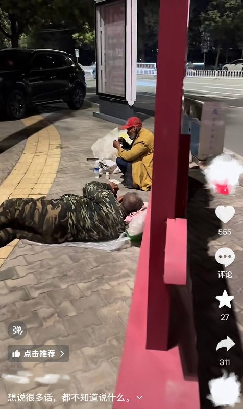 9月12日，内蒙古巴彦淖尔市临河区水源路，网友拍摄到一处“社会主义核心价值观”宣传牌，讽刺的是后面躺着两个席地而睡的流浪汉