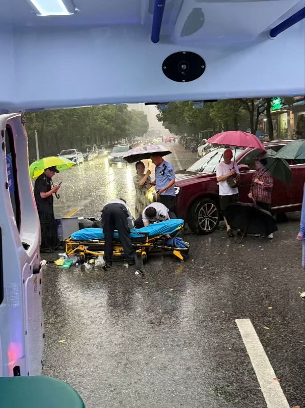 “学医的尽头到底是什么？”7月20日，某地暴雨中，医护人员正跪在积水和泥泞中进行紧急治疗，浑身已经淋透，而旁边却无一人为他们撑伞